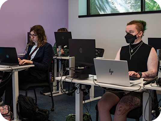 abilIT students studying on computers in a classroom