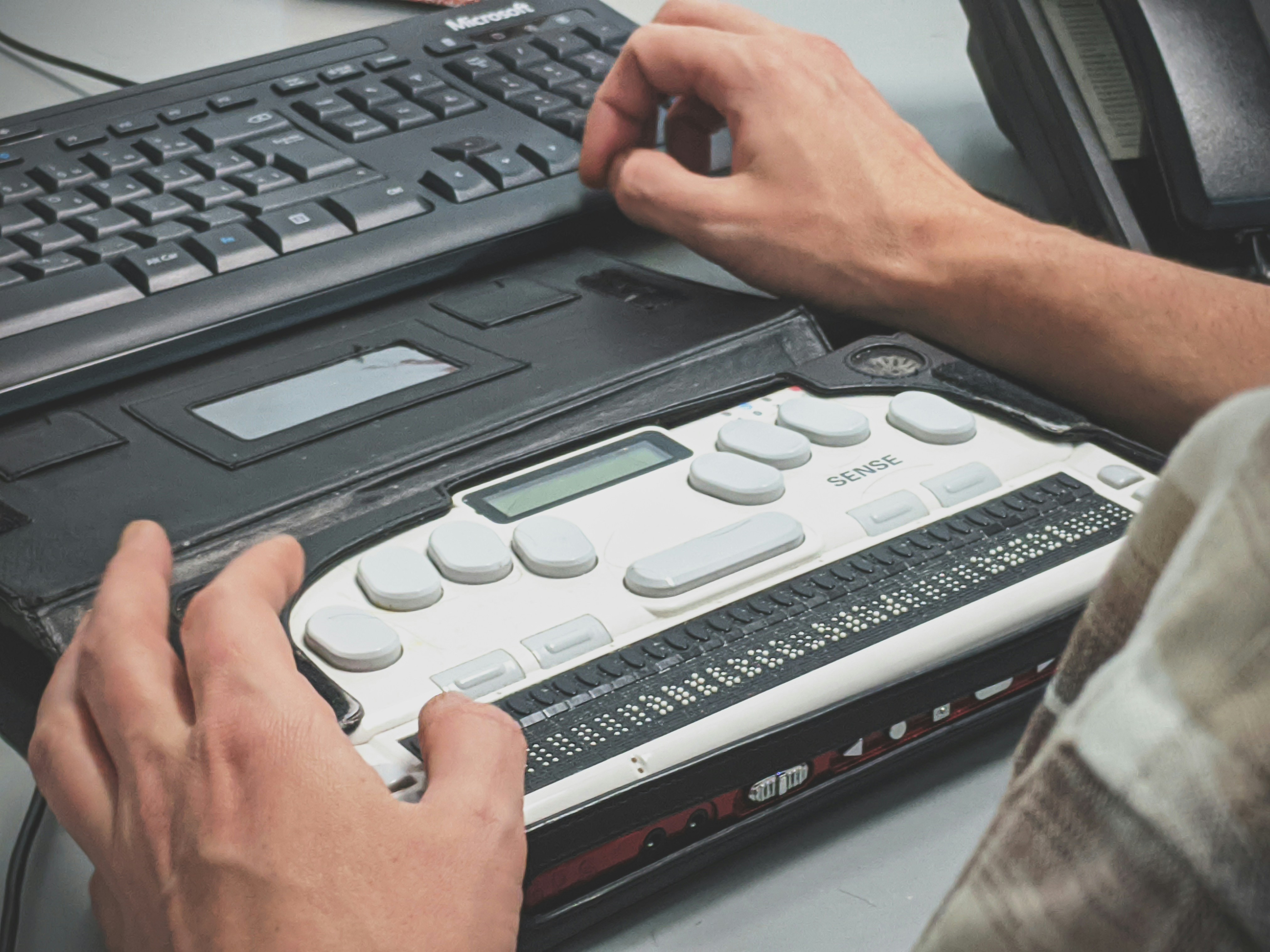 A man types on a braille typewriter